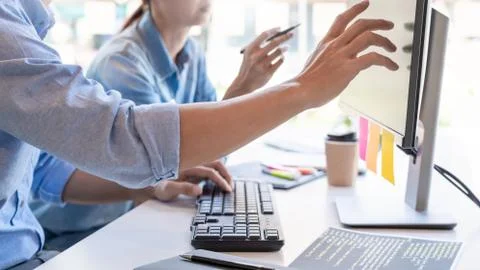 Young startup Programmers Sitting At Desks Working On Computers screen for De 写真素材