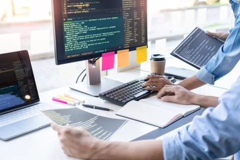 Young startup Programmers Sitting At Desks Working On Computers screen for De 库存照片