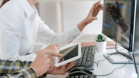 Young startup Programmers Sitting At Desks Working On Computers screen for De 写真素材