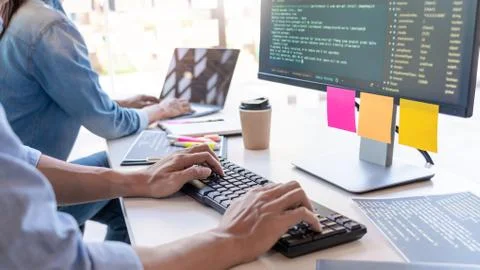 Young startup Programmers Sitting At Desks Working On Computers screen for De Stockfoto's