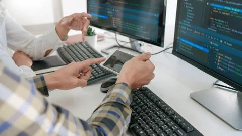 Young startup Programmers Sitting At Desks Working On Computers screen for De Foto stock