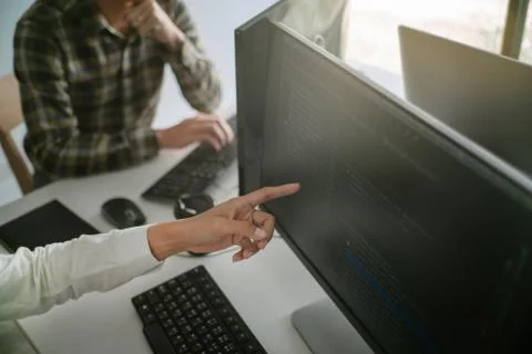 Young startup Programmers Sitting At Desks Working On Computers screen for De 写真素材
