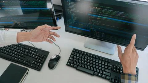 Young startup Programmers Sitting At Desks Working On Computers screen for De Stockfoto's