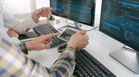 Young startup Programmers Sitting At Desks Working On Computers screen for... Foto stock