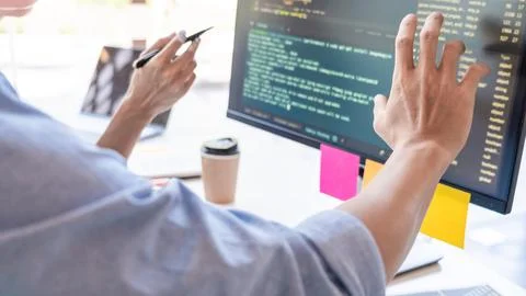 Young startup Programmers Sitting At Desks Working On Computers screen for .. Foto stock