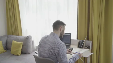 Young stock exchange trader working from home and taking notes on notepad Stock Footage 156740072