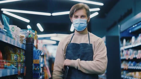Young store workman wearing apron arranging foods at supermarket. Portrait of Stock-Footage 143739926