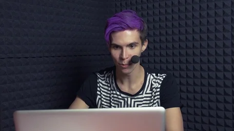 Young streamer with purple bangs taking video Let's Play review in web studio Stock Footage 70803208