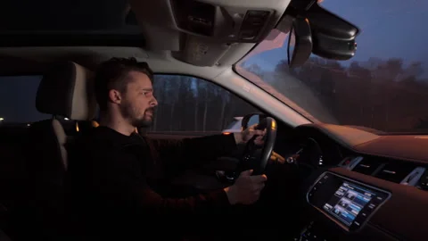 Young stressed angry guy driving a car, knocks on steering wheel Stock Footage 269378050