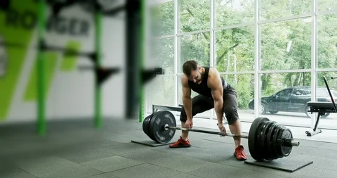 Young strong athlete does exercise with barbell. Slow motion Stock Footage 117070982