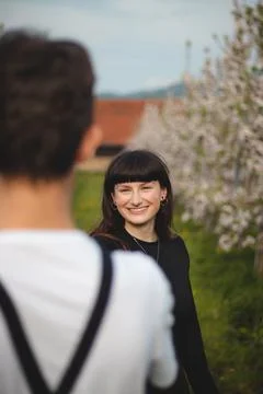 Young strong love between two young people standing under apple trees. Candid Stock Photos