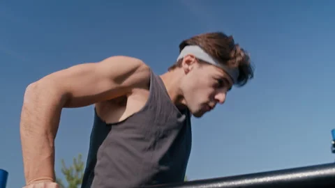 Young Strong Man Doing Dips on Parallel Bars at Outdoor Sports Ground Stock Footage 318499744