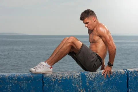 Young strong man training core muscles Stock Photos