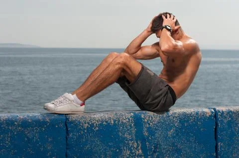 Young strong man training core muscles Stock Photos