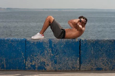 Young strong man training core muscles Stock Photos