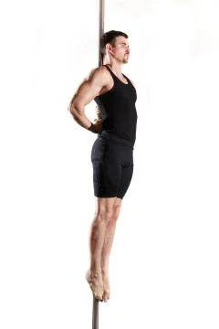 Young strong pole dancer smiling man in black clothes on pylon. White backgro Stock Photos