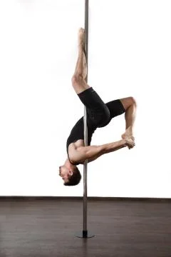 Young strong pole dancer smiling man in black clothes on pylon. White backgro Stock Photos