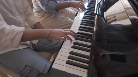 Young Student and Teacher Play Piano Together, Practicing Music in a Bright Room Vídeo Stock 345340779