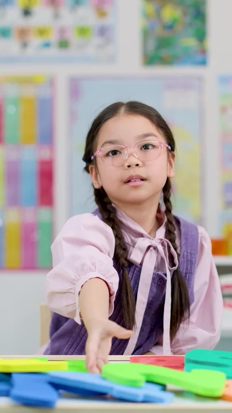 Young Student Answering Question in Colorful Classroom Setting Stock Footage 321450243
