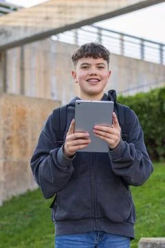 Young student with backpack holding tablet on campus Stock Photos