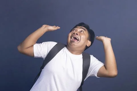 Young student with a backpack looks up with a scared and fearful expression.. Stock Photos
