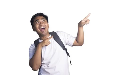 Young student with a backpack pointing up with an excited and happy facial .. Stock Photos