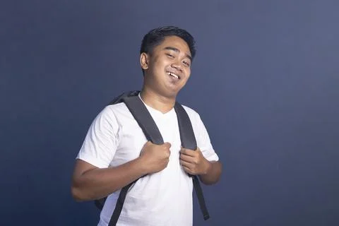 Young student with a backpack smiling and looking at the camera with a happ.. Stock Photos