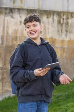 Young student with braces holding tablet on campus Stock Photos