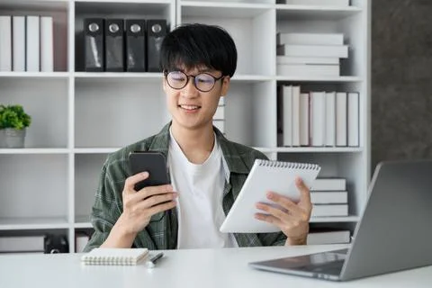 Young student busy study make notes in notebook and using laptop concentrated 스톡 사진