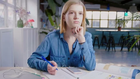 Young student can't concentrate on studying with smartphone hesitate distraction Stock Footage 103290859