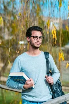 Young student of computer science poses with a robotics book next to one of the Stock Photos