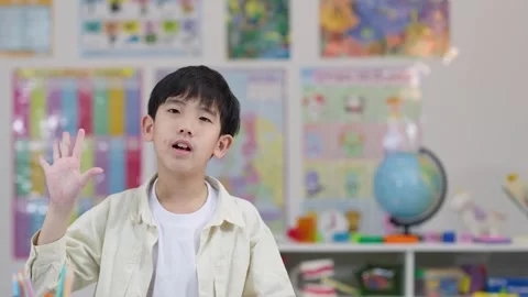 Young Student Counting on Fingers in Classroom Setting Stock Footage 324934140