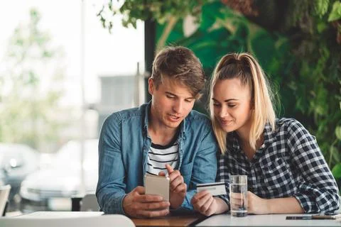 Young student couple using mobile banking to secure the deposit for their first Stock Photos