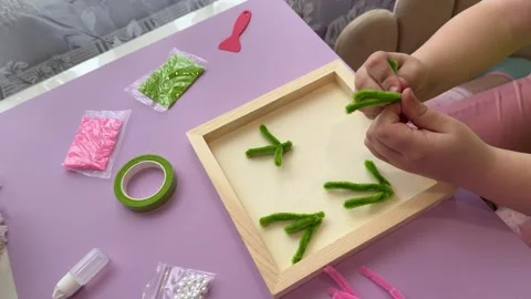 Young student creating a beautiful artwork using fuzzy craft sticks Stock Footage 342347653