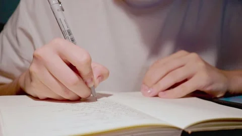 Young student doing homework in white paper notebook in close up slow motion Stock Footage 163251772