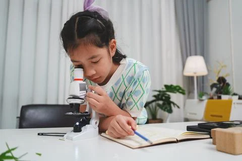 Young student exploring microscope highlighting STEM curiosity and scientific Stock Photos