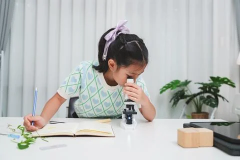 Young student exploring microscope highlighting STEM curiosity and scientific Stock Photos
