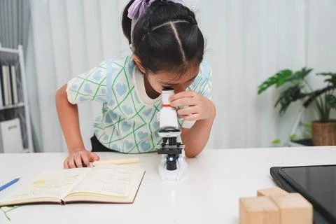 Young student exploring microscope highlighting STEM curiosity and scientific Stock Photos