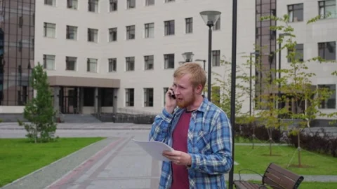 A young student goes to the background of the university talking on the phone Stock-Footage 107318052