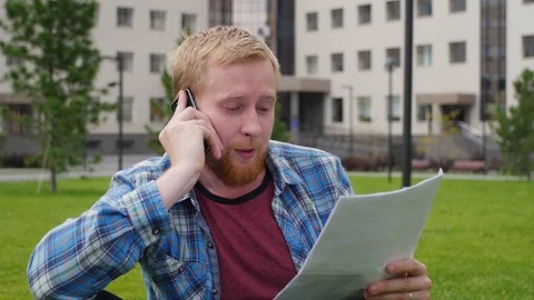 A young student goes to the background of the university talking on the phone Stockbeeldmateriaal 107318579