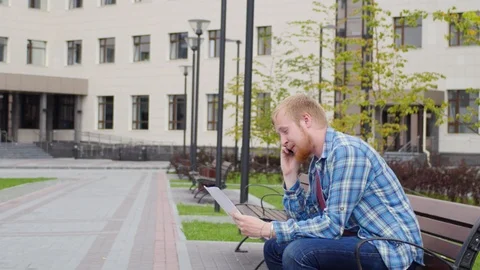 A young student goes to the background of the university talking on the phone 動画素材 107383353