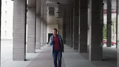 A young student goes to university talking on the phone. young businessman Видео 107316998