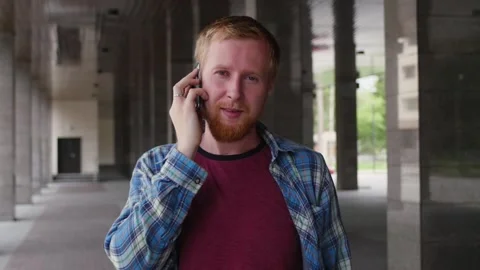 A young student goes to university talking on the phone. young businessman Vidéo 107317402
