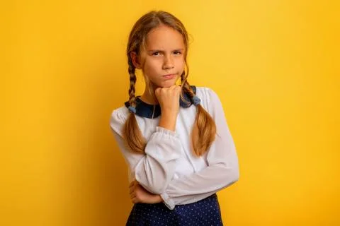 Young student has some doubt about something. yellow background Stock Photos