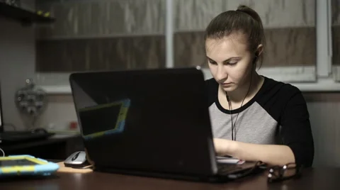 Young student with headphones makes the lessons of the laptop at night Video stock 60051847