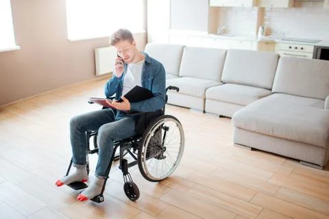 Young student with inclusion and disability. Looking on opened book and talking Stock-Fotos