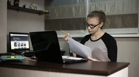 Young student looking blueprints in front of laptop at night Video stock 60051869