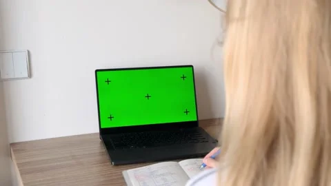 Young student looking at green screen on laptop computer, studying online class Video stock 220437005