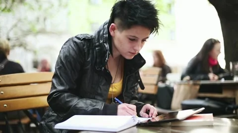 Young student with notebook and digital tablet in bar, steadicam shot HD Stock Footage 10905668