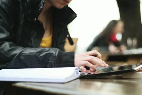 Young student with notebook and digital tablet in bar, steadicam shot NTSC Stock Footage 10905691